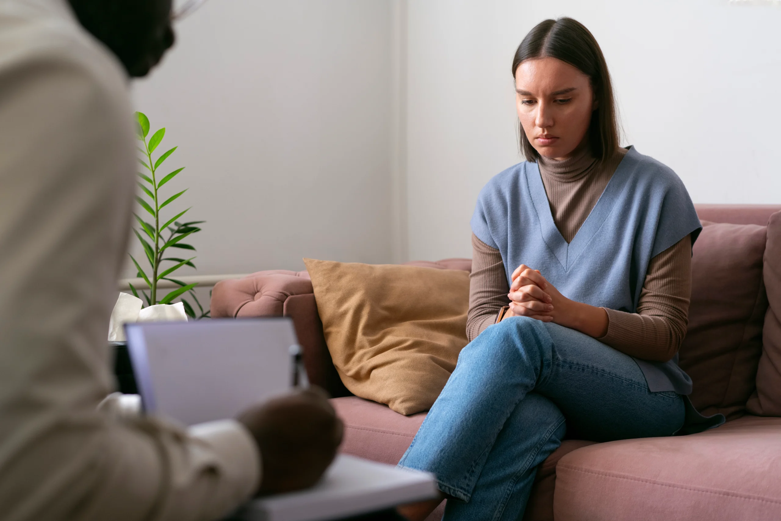 A therapist talking to a grieving family member who is looking down in sadness.