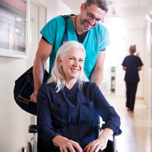 Nurse assisting a hospital patient to the lobby to be discharged.